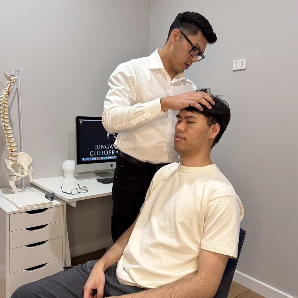 Chiropractor performing a posture assessment and spinal evaluation before treatment